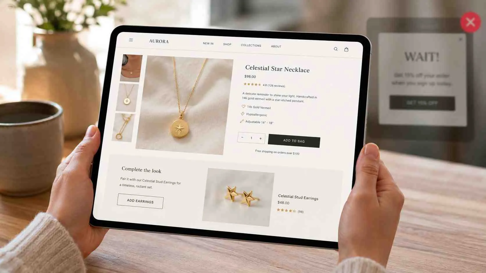 Een tablet toont een webshop pagina met een gouden ketting en een suggestie voor bijpassende oorbellen.